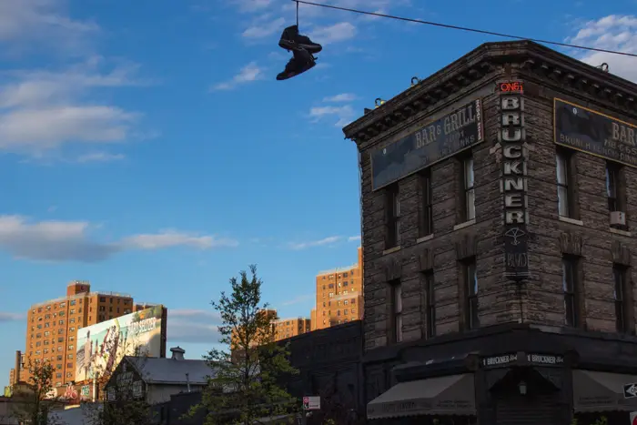 A photo of shoes hanging off telephone wire in Mott Haven